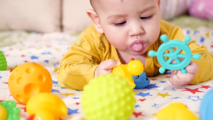 婴儿用牙齿咬玩具的特写镜头。