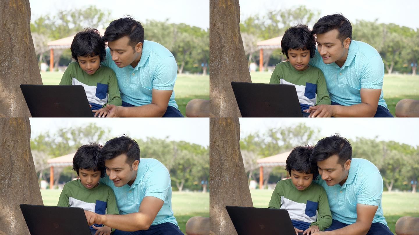 小孩从他爸爸那里学习如何使用笔记本电脑