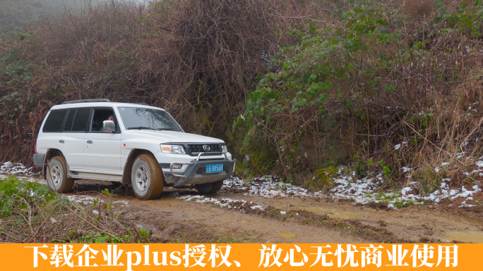 冬季山乡冰雪泥路上艰难行驶的越野车