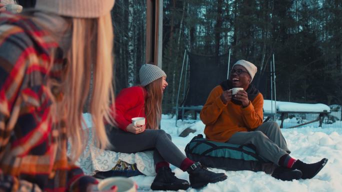 舒适的冬日雪地户外露营喝茶女性聚会