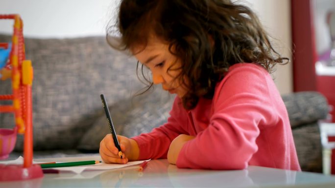 小女孩在一张纸上画画
