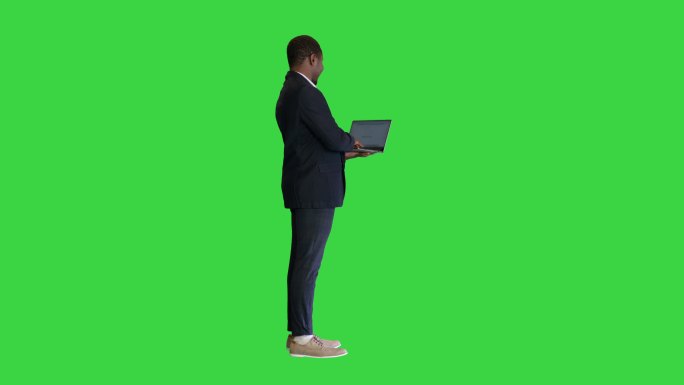 商人站在绿色屏幕上，手持笔记本电脑