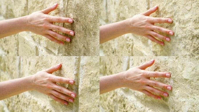 女性手触摸岩石粗糙表面