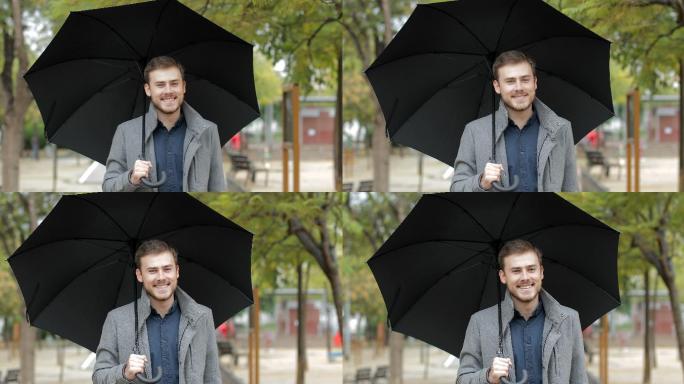 男人在雨中走在公园里，手里拿着雨伞
