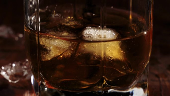 冰块漂浮并旋转。玻璃杯里的威士忌