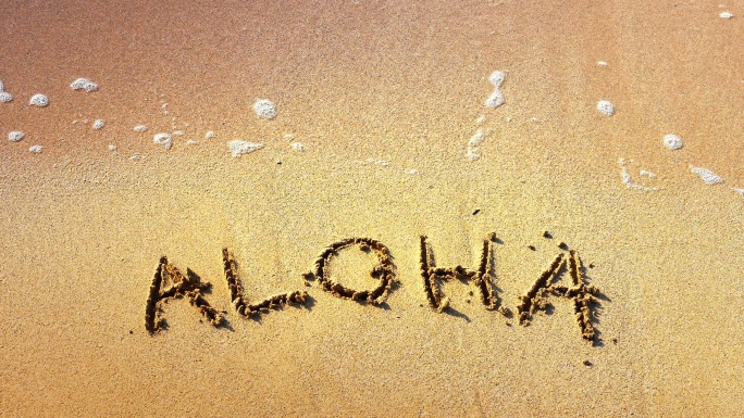 阿洛哈写在沙滩上冲刷沙子水流