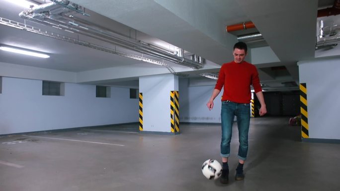 一个男人在车库里一个玩具球。