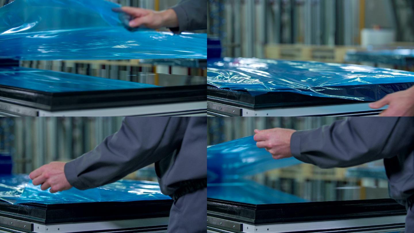 男子将蓝色保护箔覆盖在最终产品窗口上