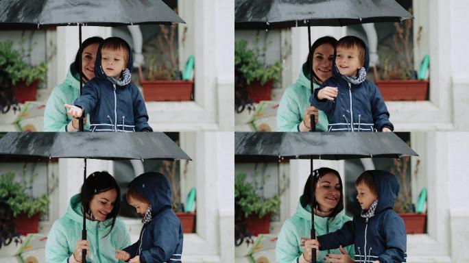 下雨时母亲和儿子躲在雨伞下