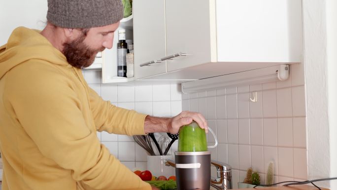 绿色的健康果汁男人使用榨汁机居家榨汁器