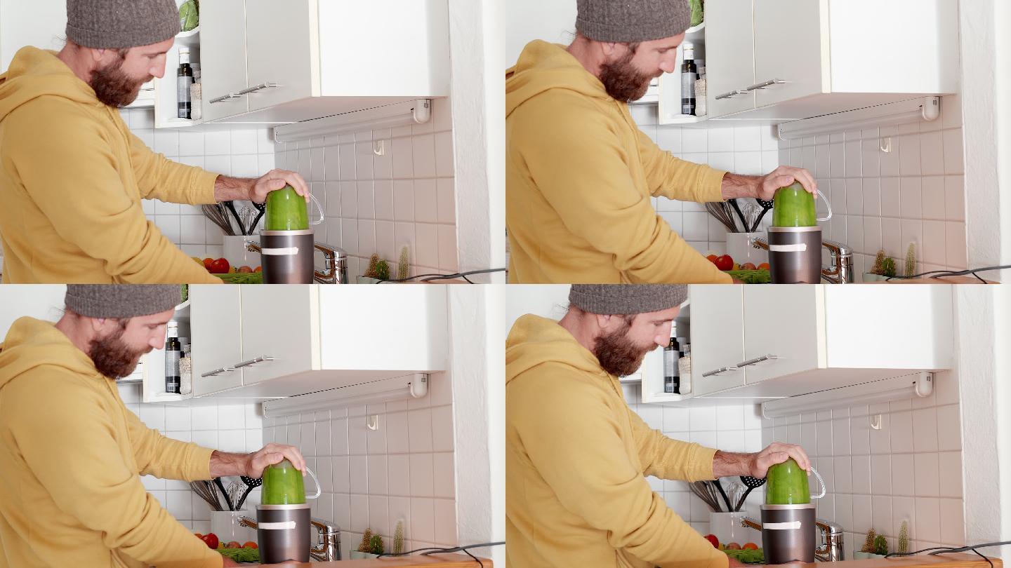 绿色的健康果汁男人使用榨汁机居家榨汁器