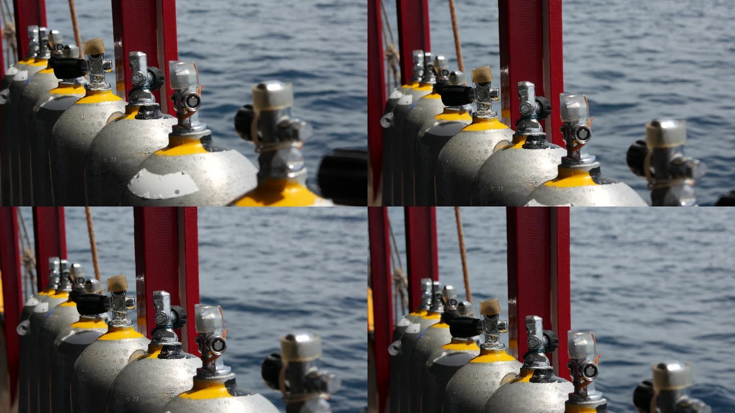 一排氧气罐和潜水设备放置在船上。