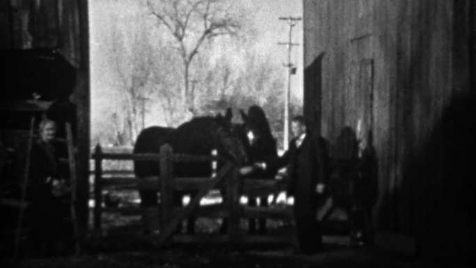 1933年：一位老人在室外马厩喂马。