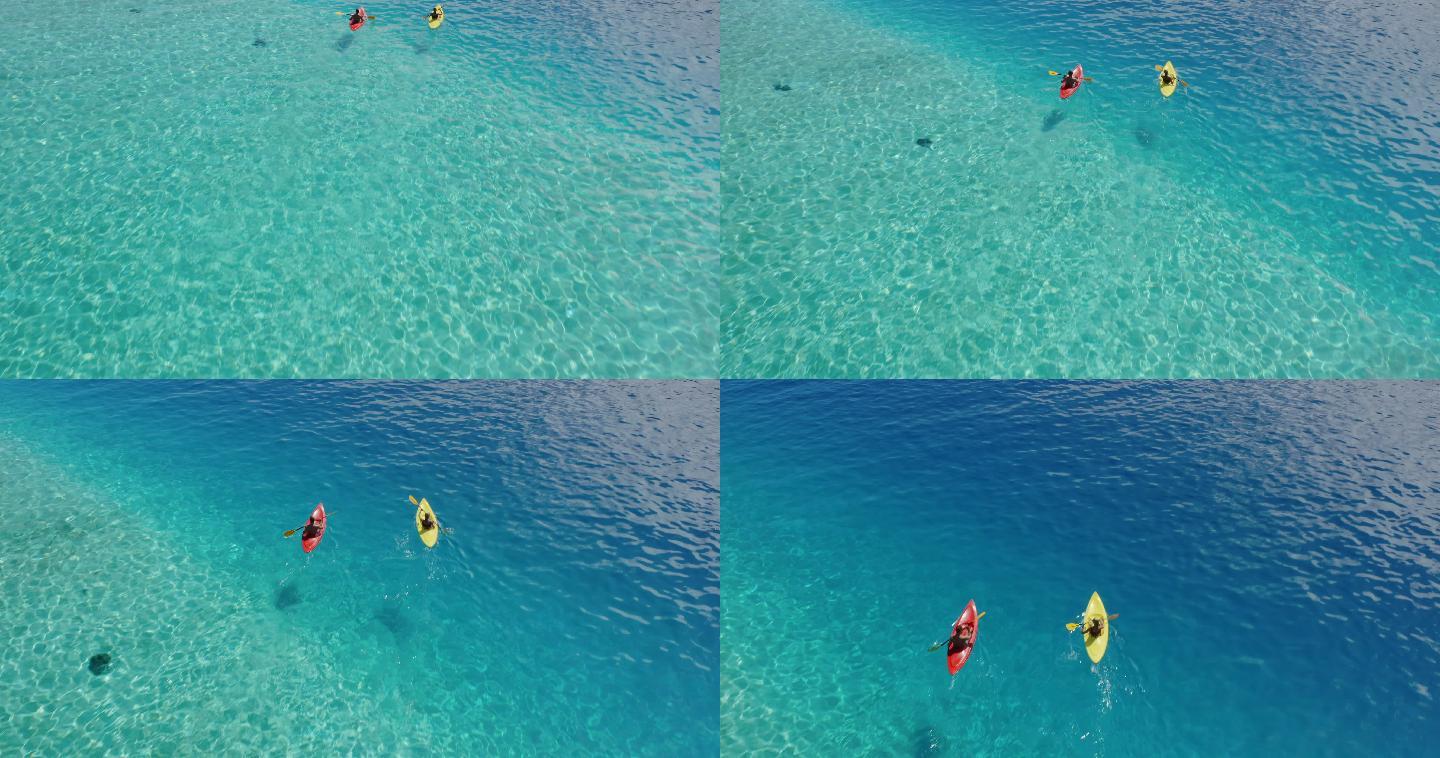 两名皮划艇运动员在纯净的蓝色海水中划水