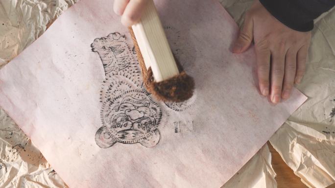 艺术家在木刻版上拓印出老虎