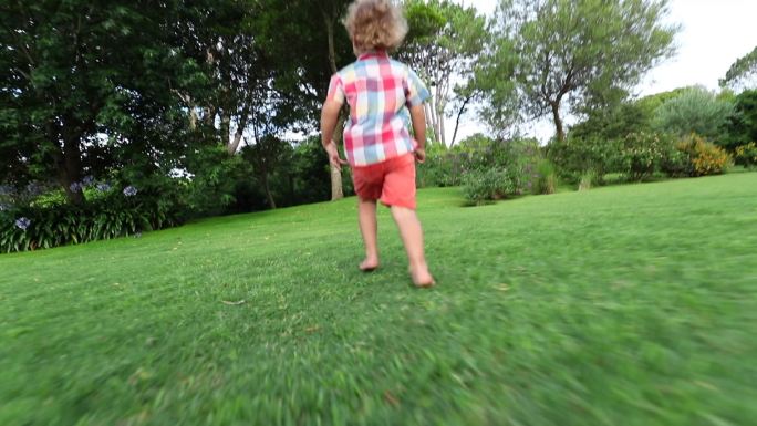 草地上奔跑的小男孩