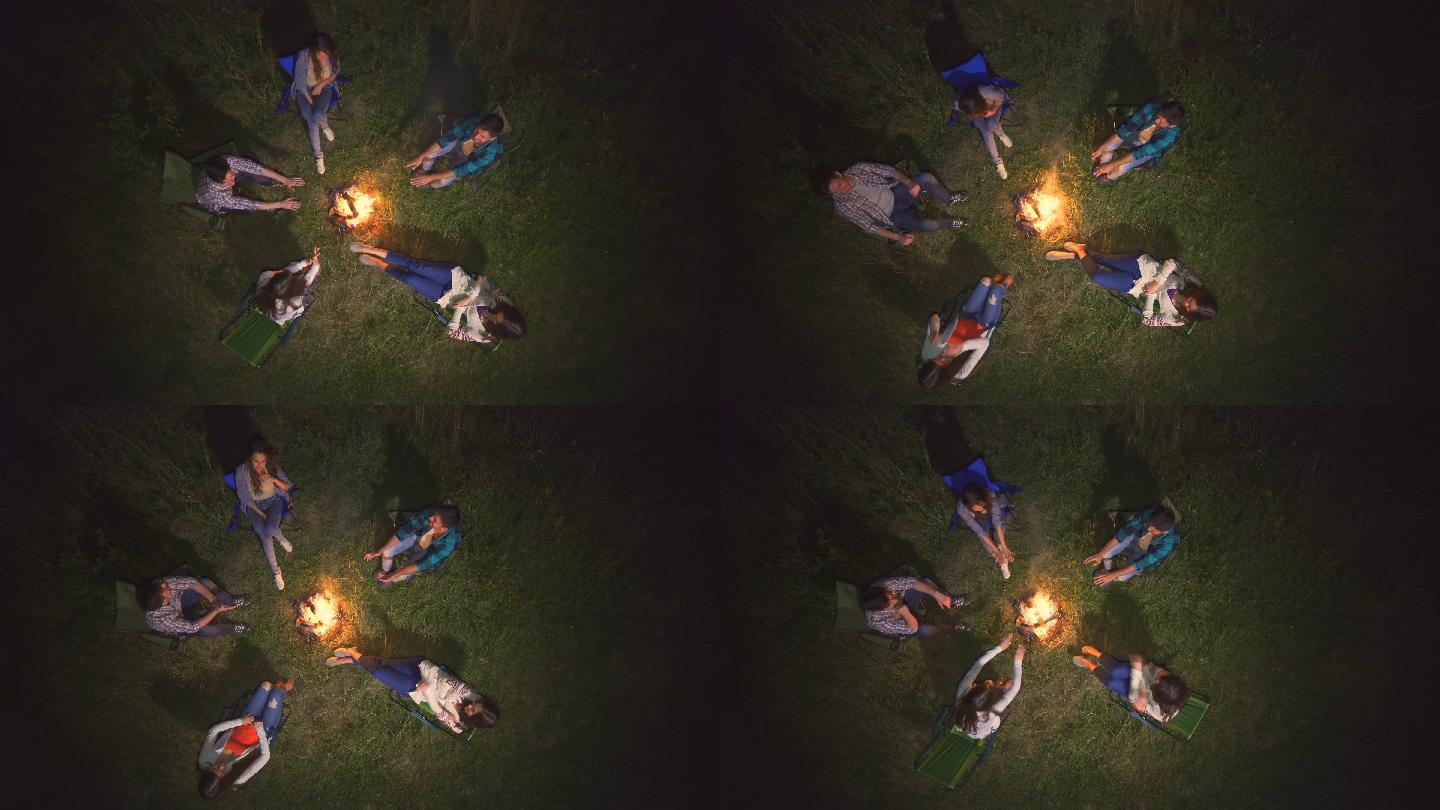 五个人坐在篝火旁聊天