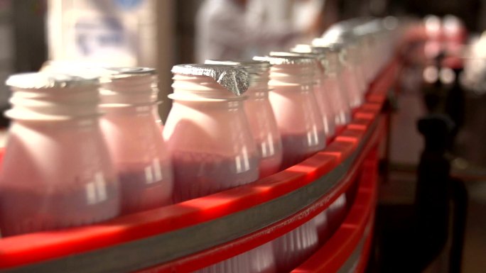 白色塑料酸奶瓶在一条新的输送线上