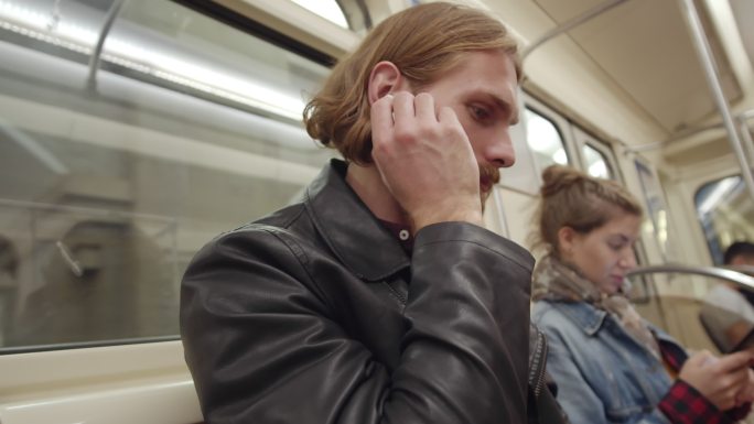 乘客在地铁内使用耳机