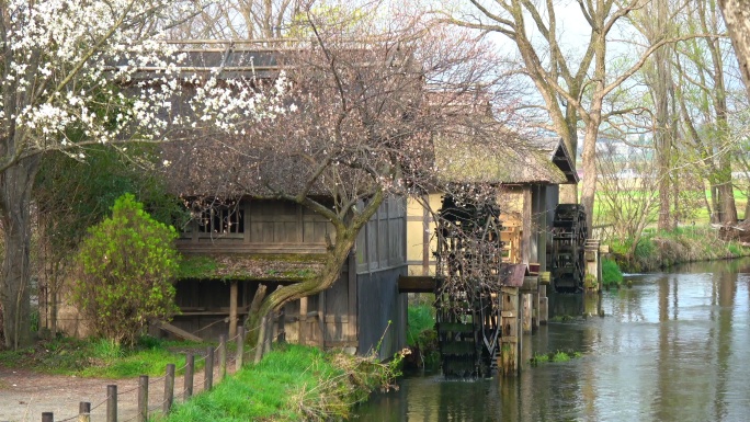 乡村小屋旁的水车农村民宿木屋古代