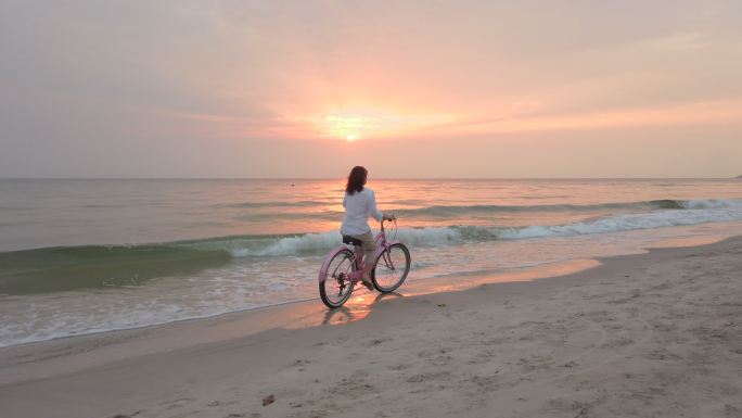 海滩上骑自行车的女人