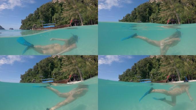 女性在热带水域浮潜的半对半离水镜头