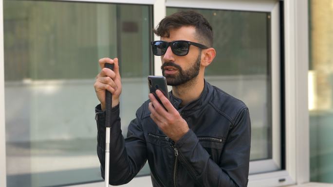 一个失明的年轻人正在使用智能手机
