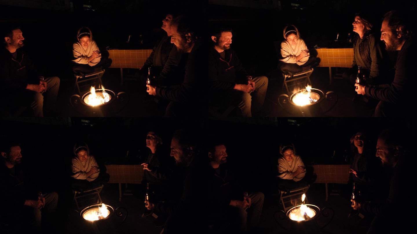 夜晚，两男两女坐在后院的火坑旁聊天。