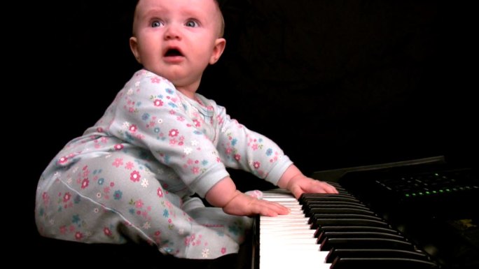 女婴在玩键盘幼儿黑白键哭闹