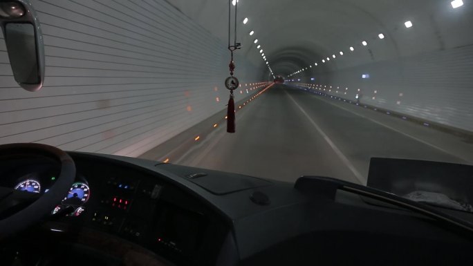 大客车夜间行驶在马路隧道