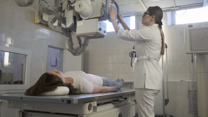 女医生在医院诊断室为女孩操作医用x光机