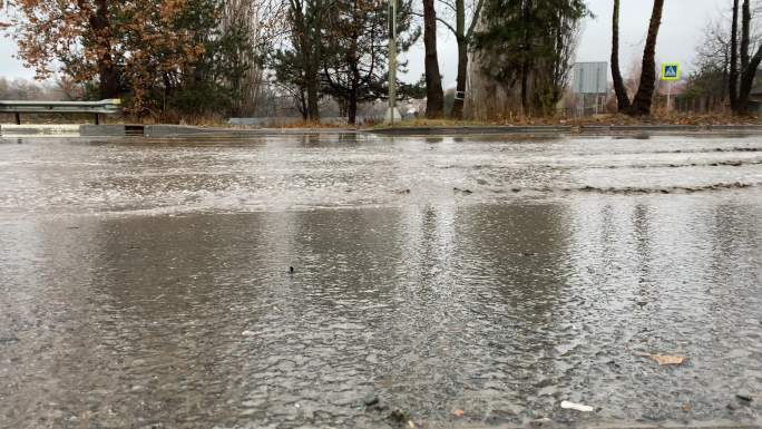 雨天潮湿路面上的城市交通车辆驶过水坑