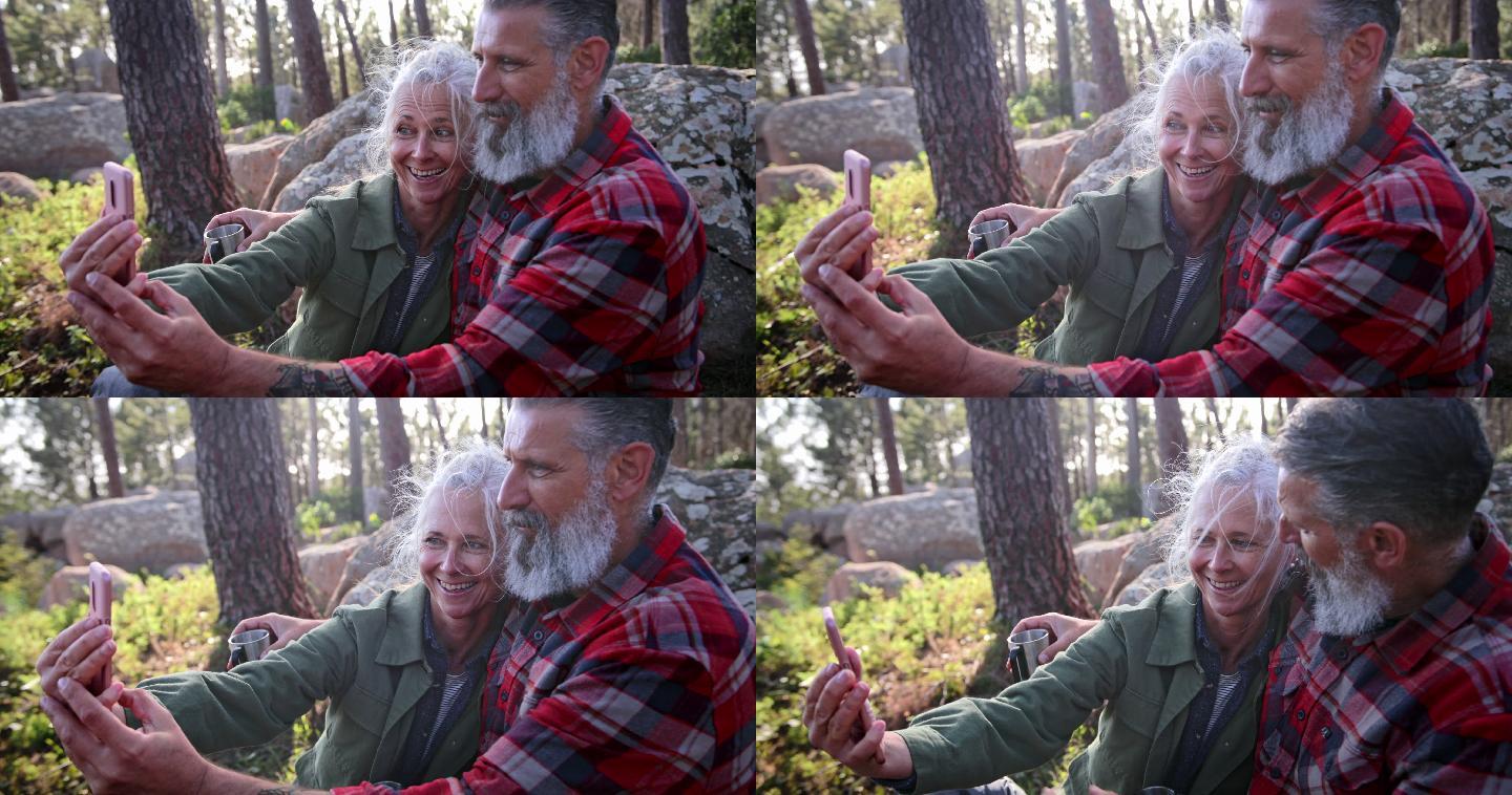 在森林里用智能手机自拍的老年夫妇