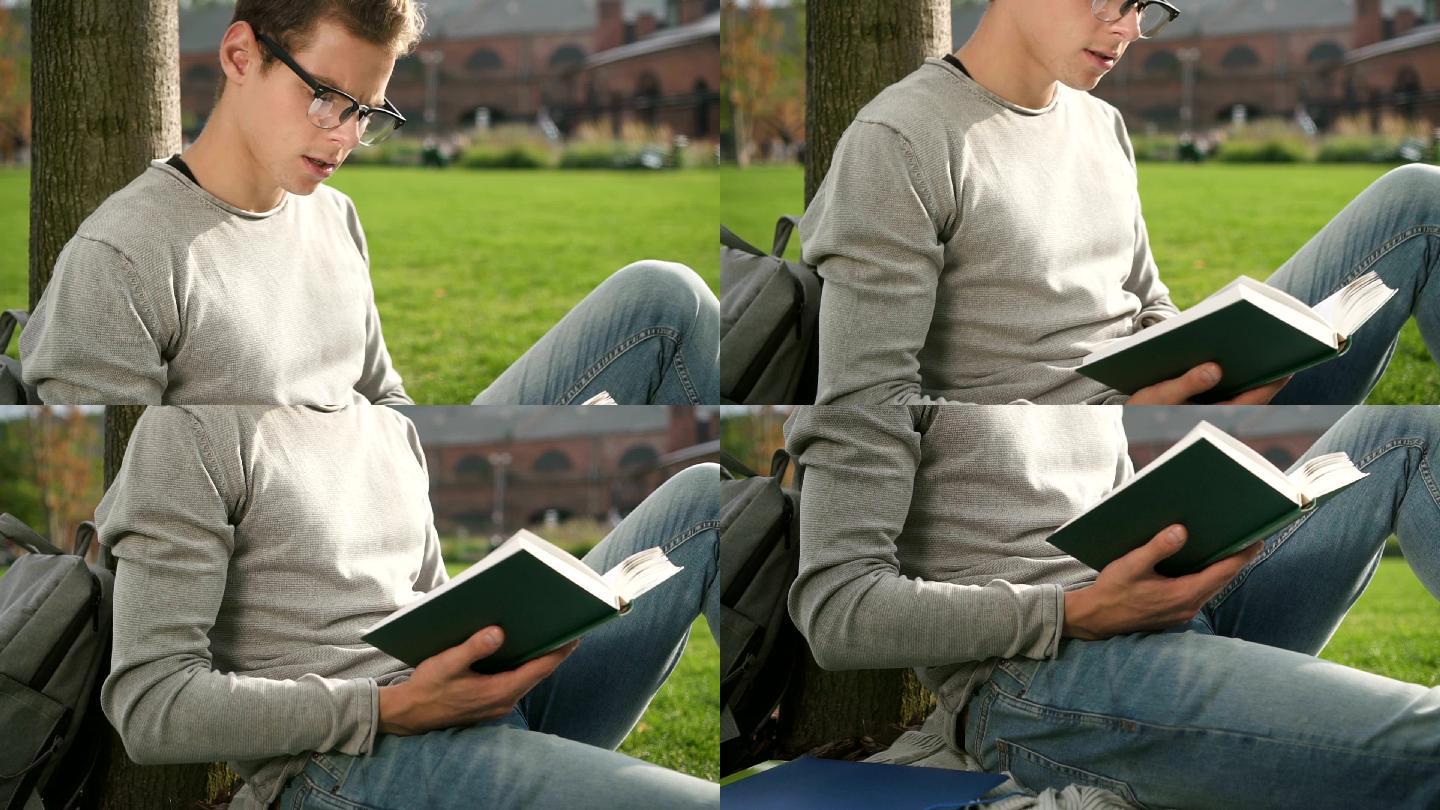 男人坐在草坪上读书