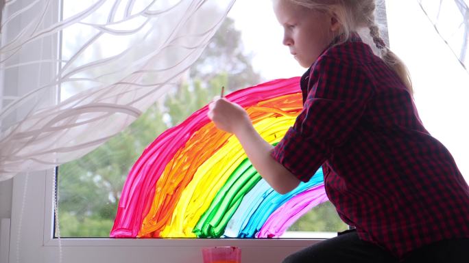 在玻璃上画彩虹的小女孩