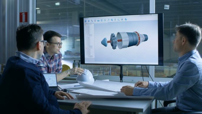 工业工程师团队讨论演示显示屏上显示的3D涡轮