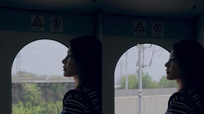车厢内站在车窗旁看风景的青年女人