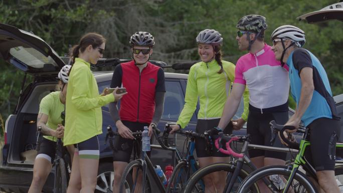 一群骑自行车的人一起看手机上的照片