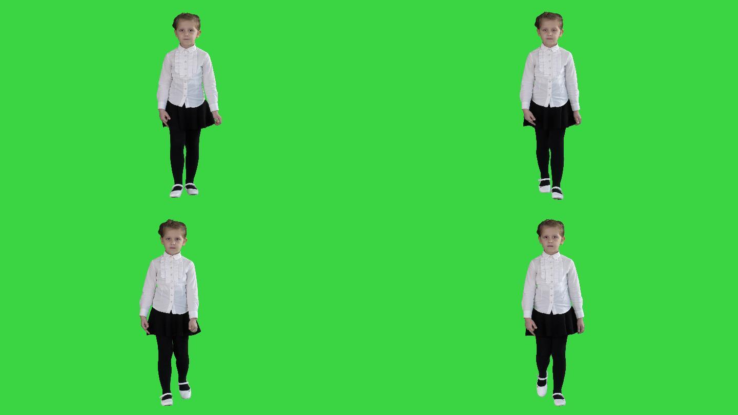 一个严肃的小女孩走在绿色屏幕上