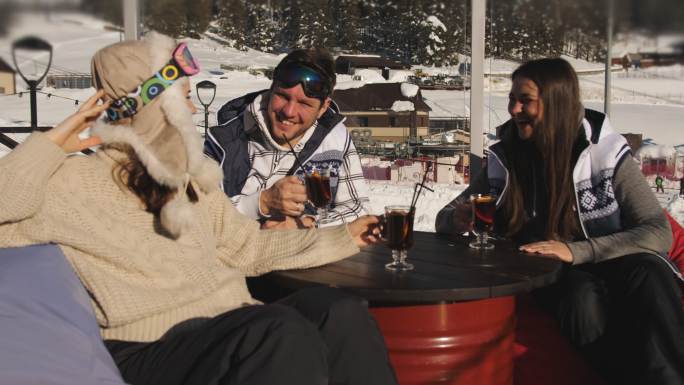 滑雪者在滑雪胜地的咖啡馆里喝着热葡萄酒