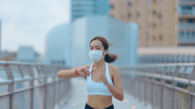 在城市公园路慢跑的年轻女子