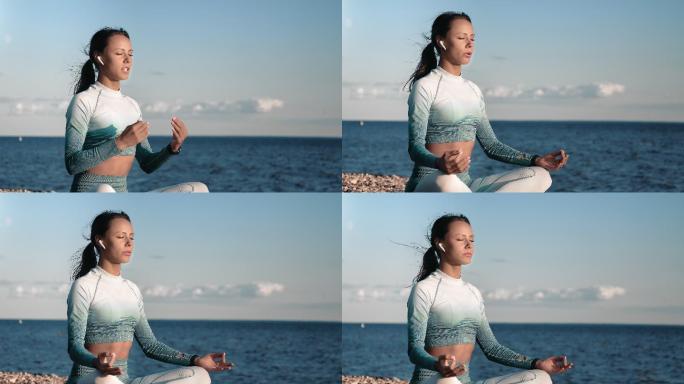 女士戴着耳机听音乐在海滩上练习瑜伽