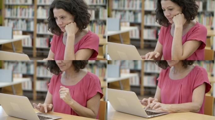 女人坐在图书馆的桌子旁，用笔记本电脑工作