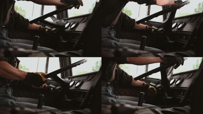 男卡车司机坐在驾驶室转动方向盘。