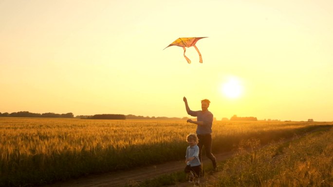 日落时分父子俩在大自然中玩风筝