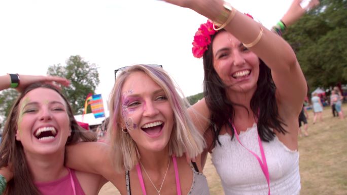 三位年轻的女性朋友在音乐节上玩得很开心