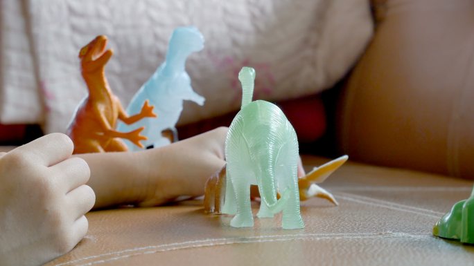可爱的女孩玩塑料恐龙