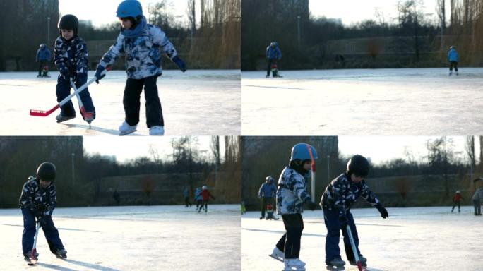 男孩在冰冻的湖面上的公园里打曲棍球和滑冰