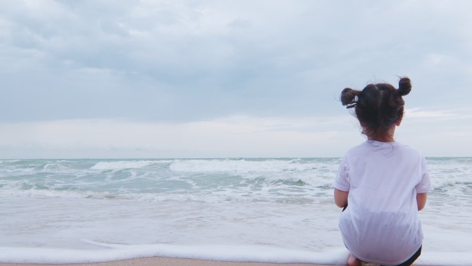 女孩坐在海边看着大海