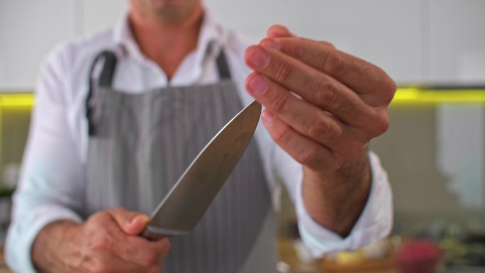 厨师在准备食物之前先把刀子磨快